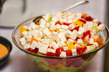 Cheese and tomato cubes in a glass bowl at a celebration.