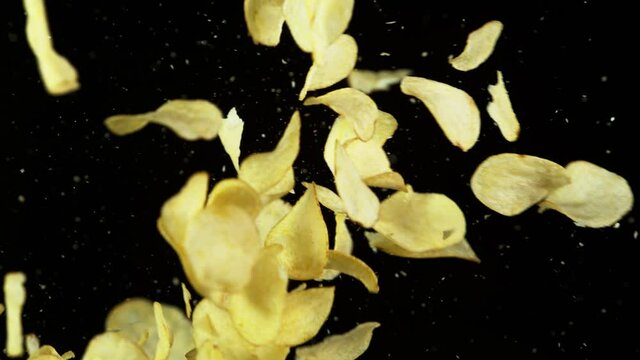 Super slow motion of flying fried potatoes chips hitting up in the air. Filmed on high speed cinema camera, 1000 fps.