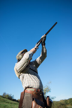 Hunter aiming his shotgun at a duck hunting in France