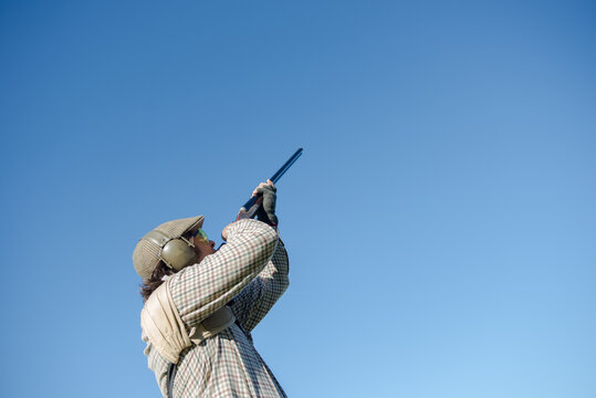 Hunter aiming his shotgun at a duck hunting in France