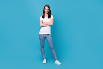 Fototapeta na wymiar Full length photo of attractive business lady hold arms hands crossed worker success career top manager confident person wear casual white t-shirt jeans shoes isolated blue color background