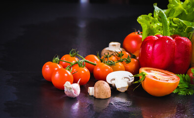Set of fresh vegetables on black stone background. red pepper, tomato, green oak, cos, Romaine, garlic, asparagus, mushroom and coriander with copy space.
