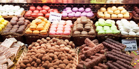 french macarons and other sweets on counter of market
