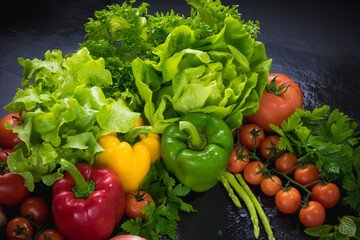 Set of fresh vegetables on black stone background. red yellow and green pepper, tomato, green oak, cos, Romaine, garlic, asparagus, mushroom and coriander with copy space.