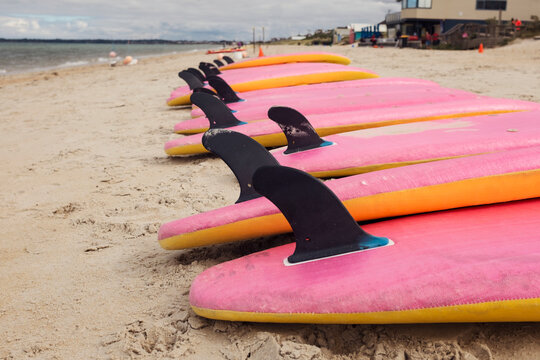 Surfboards in a row at the beach.