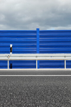 Road guardrail detail with a sign pole