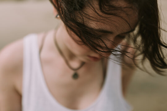 Closeup Lifestyle Photo of Woman / Girl with her Hair Blowing in the Wind Outdoors