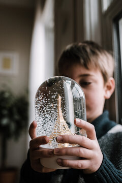 little boy with Eiffel tower snow globe
