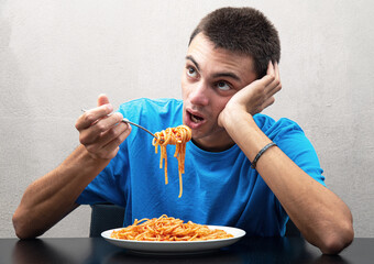 young man eating spaghetti with inappetence