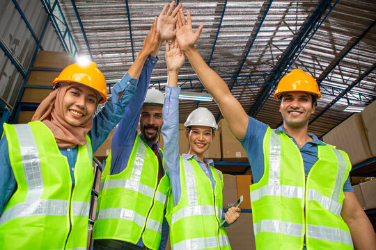 Warehouse worker team using hands touching for union teamwork in company