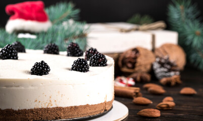 Close-up shot of delicious blackberry cake on wooden cutting board and on black