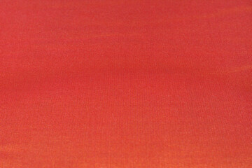 Closeup orange color fabric texture background with natural light.