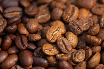 Mixture of different kinds of roasted coffee beans background.