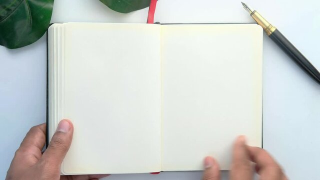man's hand turning a pager of a diary 