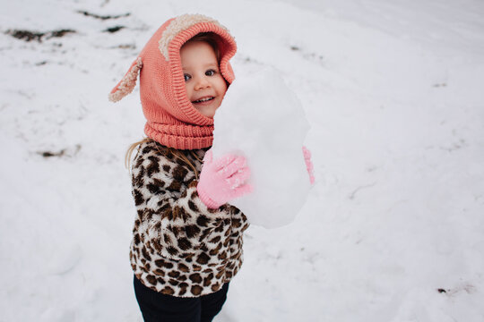 Toddler Girl Holding A Big Snowball