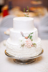 Fototapeta na wymiar White wedding cake decorated with living flowers. Fine art background.