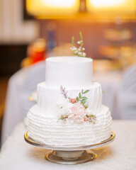 Obraz na płótnie Canvas White wedding cake decorated with living flowers. Fine art background.
