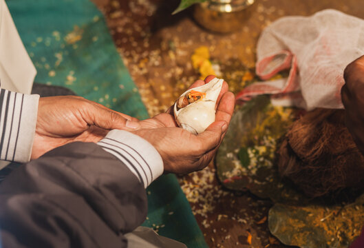 Close up of the shell in man's hands during Hindu ceremony