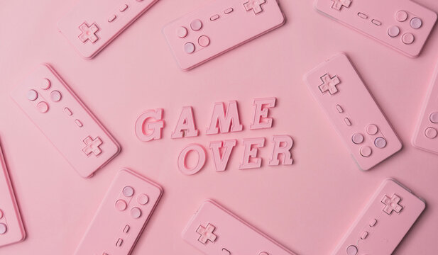 Gaming console josticks arranged with word ""Game over""