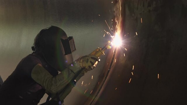 Medium shot of man welding on pipe, Dolakha, Nepal