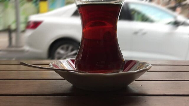 a glass of tea in the street, blurry traffic background	