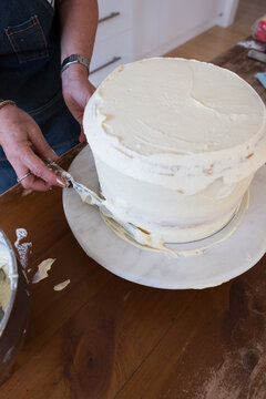 Layer cake with cream frosing being applied