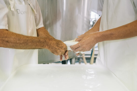 Cheesemakers pulling Buffalo Mozzarella balls
