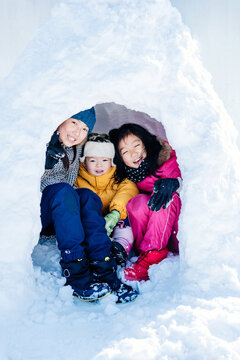 three kids sitting in Igloo house