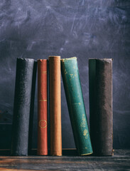 Vintage old books on blackboard background, vertical