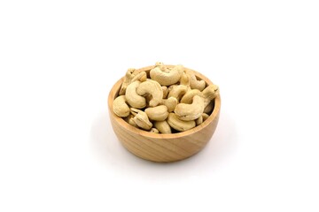 Raw cashew nuts in wooden cup on white background