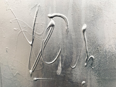 The word "YOU" written on wall, close up