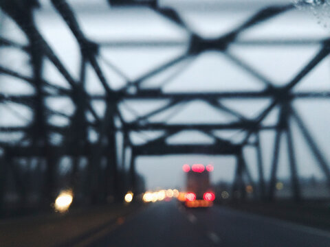 Blurred view through car windshield of bridge and oncoming traffic