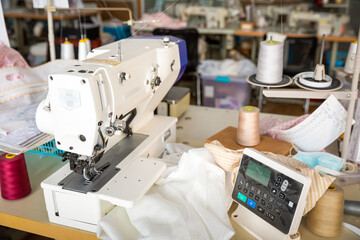 A row of textile looms weaving cotton yarn in a textile mill.