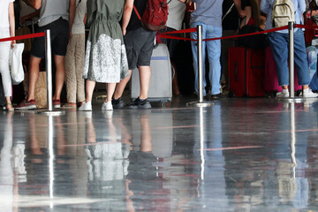 Queue of people in the airport terminal, selective focus. Passengers during registration to board the plane
