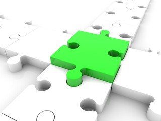 A piece of green puzzle as a connecting link between a white puzzle