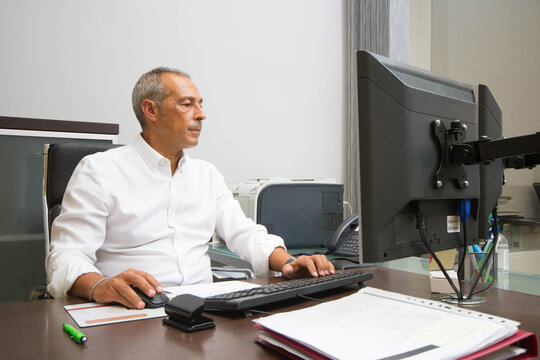 A Male Team Leader Works Hard In Front Of His Computer In An Office.Team Of Young People On A Working Day In A Farm Administration Office In Spain