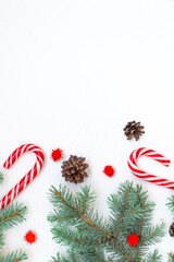 Christmas composition. Fir branches, cones, New Year's lollipop, red decorations on a white background. Christmas, winter, new year concept. Flat lay, top view, copy space