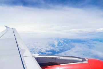 Aircraft Jet Engine turbine wing high above the clouds.