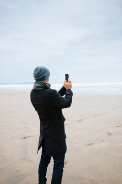Man taking a picture of the sea with his phone