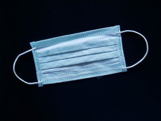 Medical protective mask on blue background. Disposable surgical face mask cover the mouth and nose.