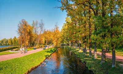 Panorama of the autumn Park with silhouettes of walking people. Gatchina. Russia