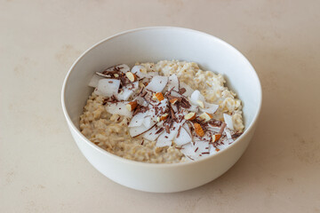 Oatmeal porridge with almonds, coconut and chocolate. Healthy eating. Vegetarian food. Breakfast. Diet.