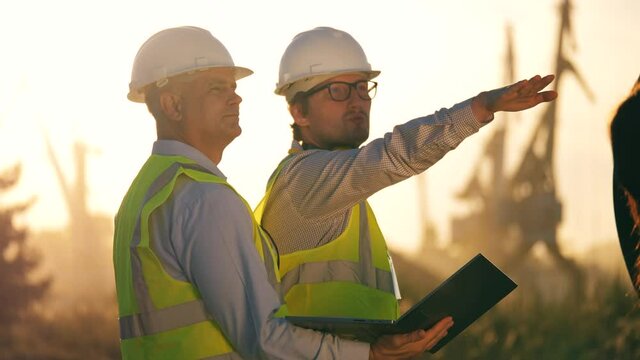 Male engineers in hardhats are discussing a project