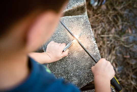 A Child Learns To Start A Campfire
