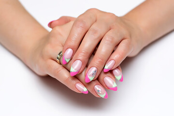 Pink mint French manicure with silver rhombuses on sharp long nails close-up on a white background. Gel lay-out manicure.