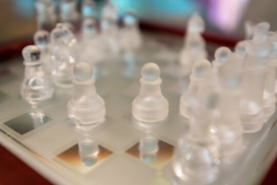 glass chess figurines playing game on chess board