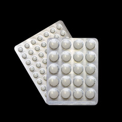 blisters with white tablets close up top view isolated on a black background