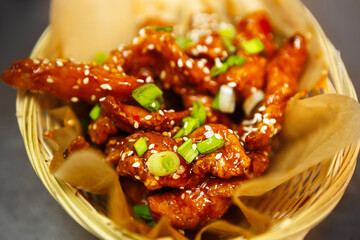 Delicious chicken strips fried in soy sauce for dinner in Asian fast food restaurant.Tasty natural poultry meat cooked in deep fryer oven,served with sesame seeds
