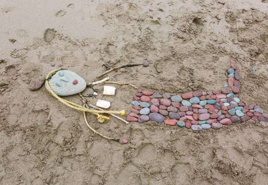A mermaid made from beach stones and debris