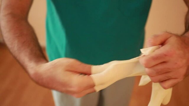 Detalle medico quit&aacute;ndose guantes de las manos